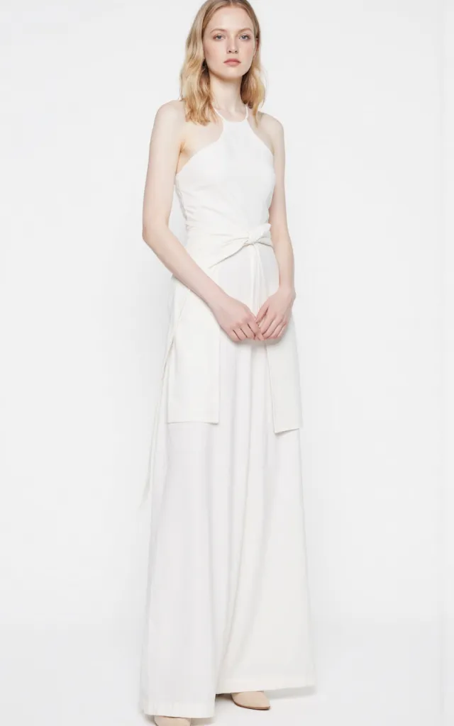 A French female model wearing Minimal   elegant   style clothing, against a white background, in a front   facing shot focusing on shoes